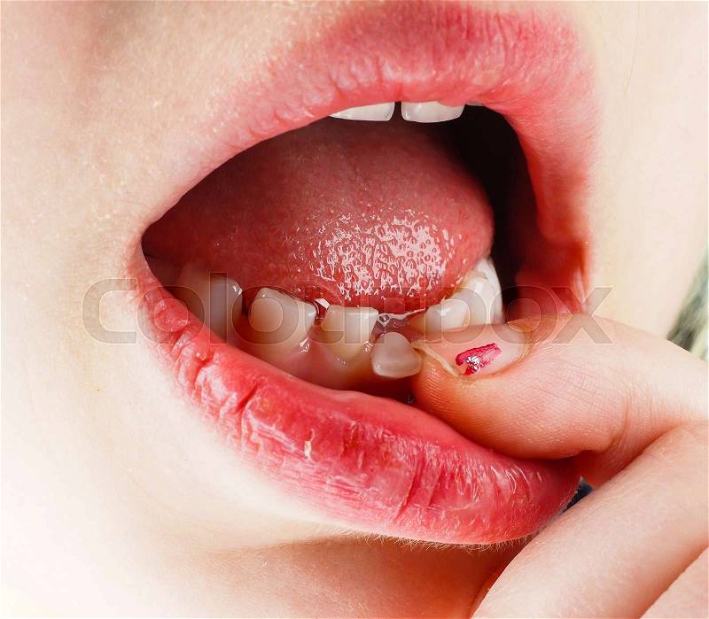 Closeup of finger feeling a lose tooth in a little girls mouth, stock photo