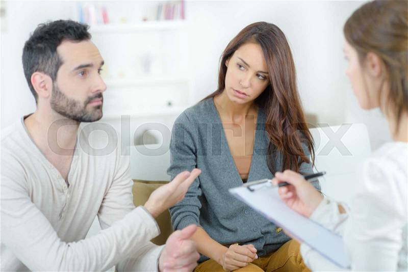 Stressed young couple quarrel at the psychologist, stock photo