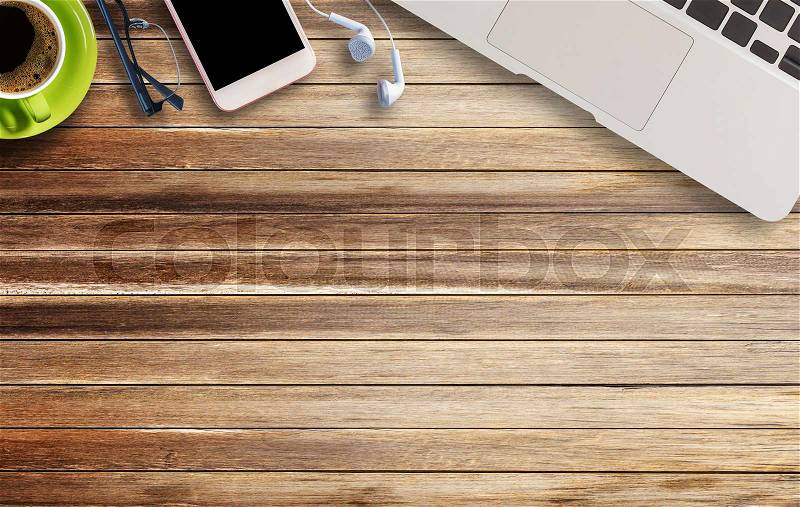 Laptop computer,glasses,earphone and smart phone on brown old wood background and texture with copy space, stock photo
