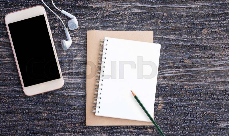 Top view pencil,note paper, smart phone and earphone on office desk with copy space, stock photo