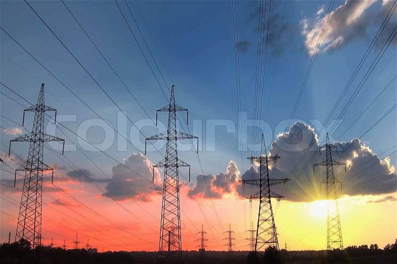 Energy Distribution Network - Electricity Pylons against Red and Yellow Sunset, stock photo