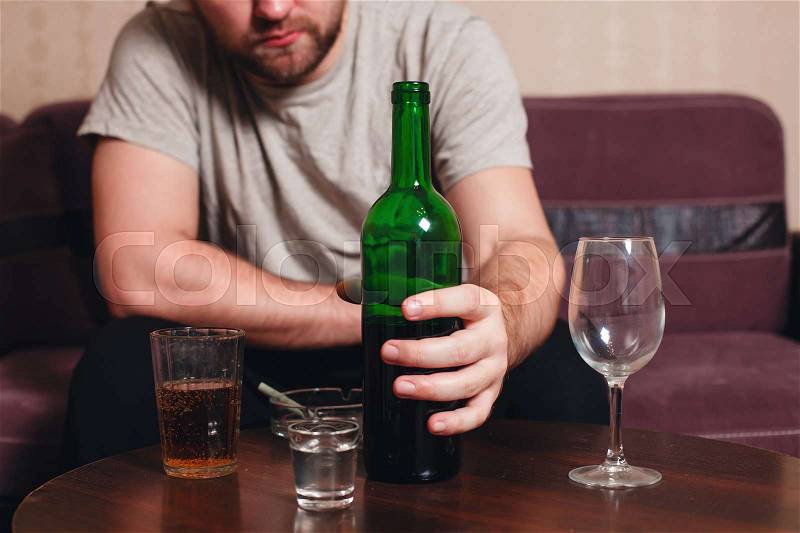 Anonymous alcoholic person hard drinking alone, stock photo