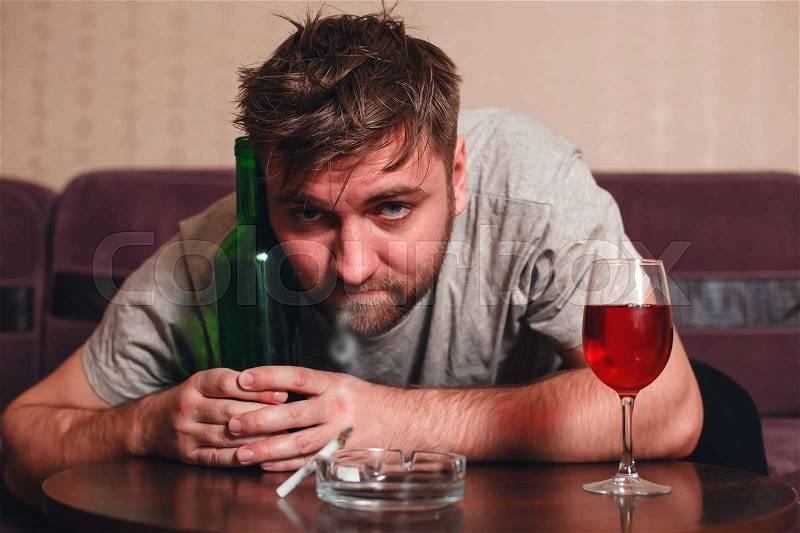 Anonymous alcoholic person in depression hard drinking alone, stock photo