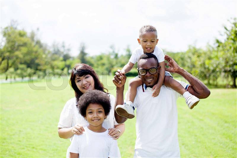 Happy diverse and mixed race family group photo in the park, stock photo