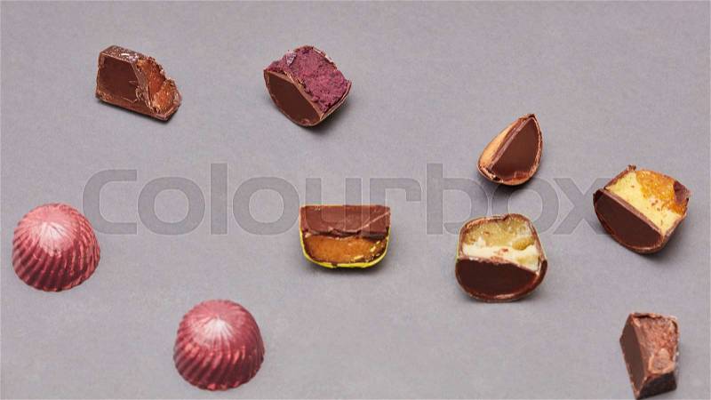 Brown candy chocolate and cut on a gray background, stock photo