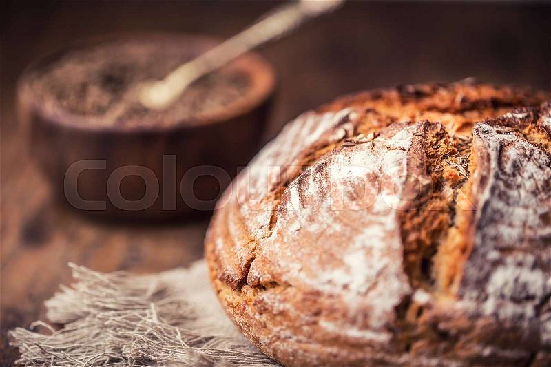 Bread.Fresh round crisp bread with caraway on wooden table, stock photo