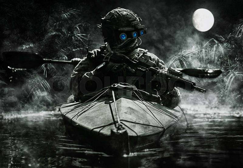 Two special forces operators with night vision goggles paddling in the army kayak in the jungle. Cloudy night, full moon, damp, stock photo