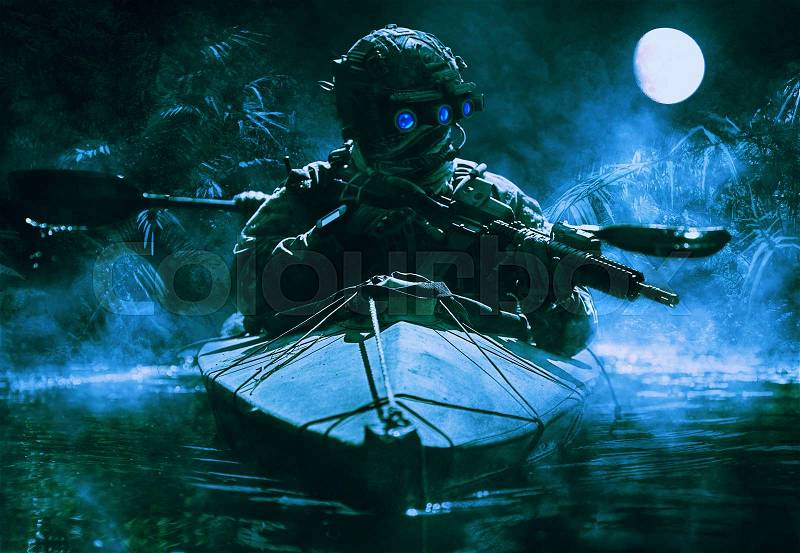 Two special forces operators with night vision goggles paddling in the army kayak in the jungle. Cloudy night, full moon, damp, stock photo