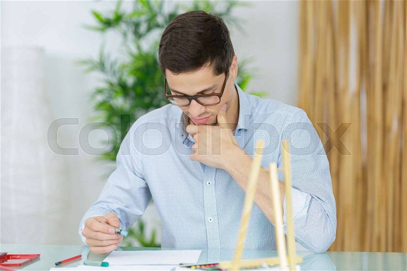 Engineer working with blueprint on panel board indoors, stock photo
