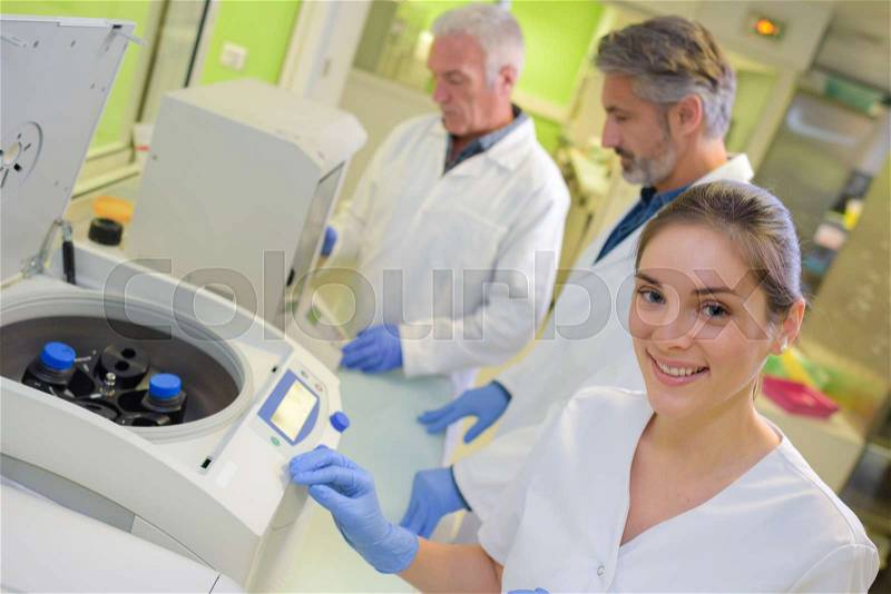 Portrait of lab worker next to equipment, stock photo