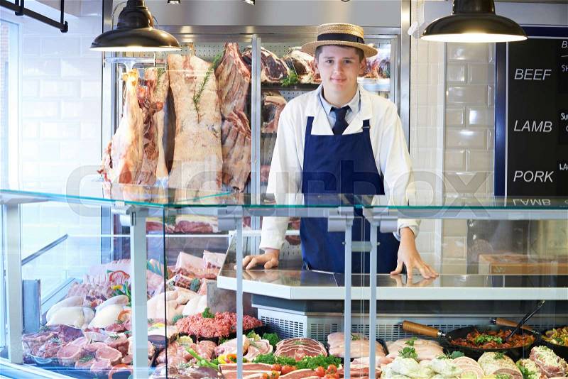 Portrait Of Butcher Standing Behind Counter, stock photo