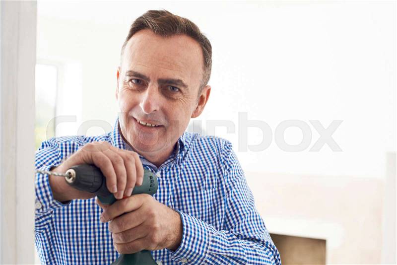 Man Using Electric Drill In House Renovation Project, stock photo