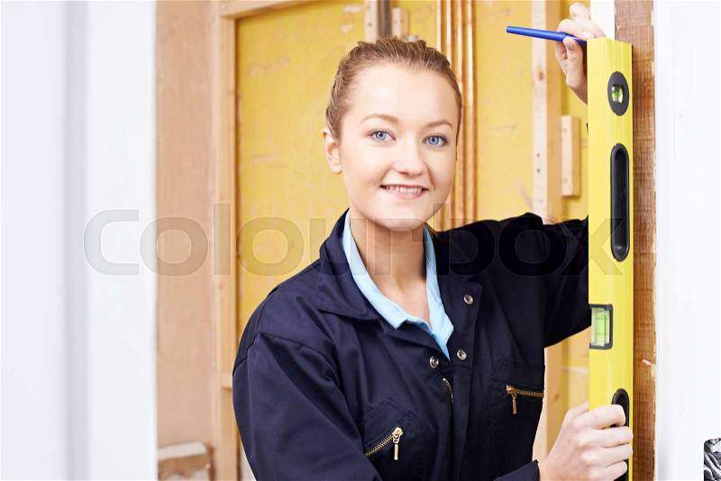 Female Builder Checking Work With Spirit Level, stock photo