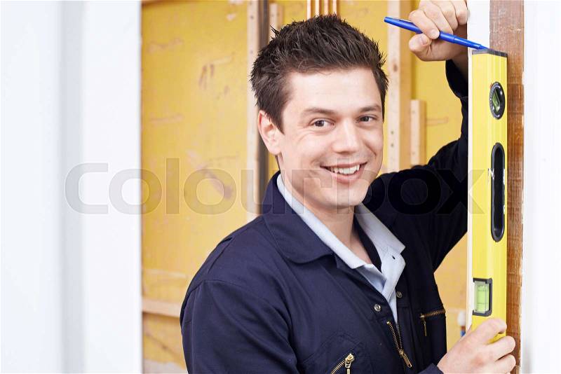 Portrait Of Builder Checking Work With Spirit Level, stock photo