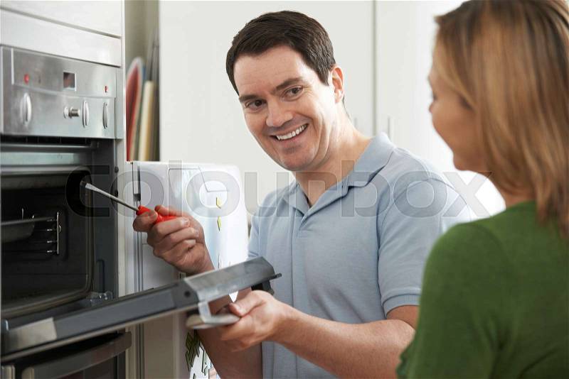 Engineer Giving Woman Advice On Kitchen Repair, stock photo