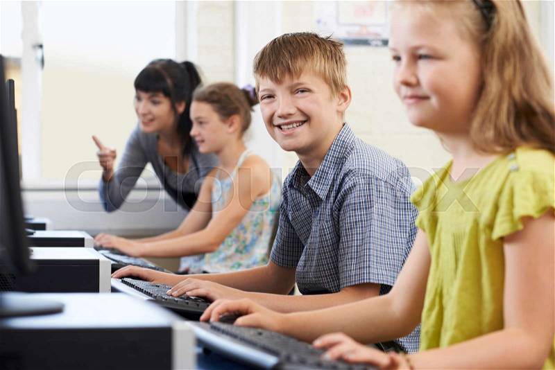 Male Elementary Pupil In Computer Class With Teacher, stock photo