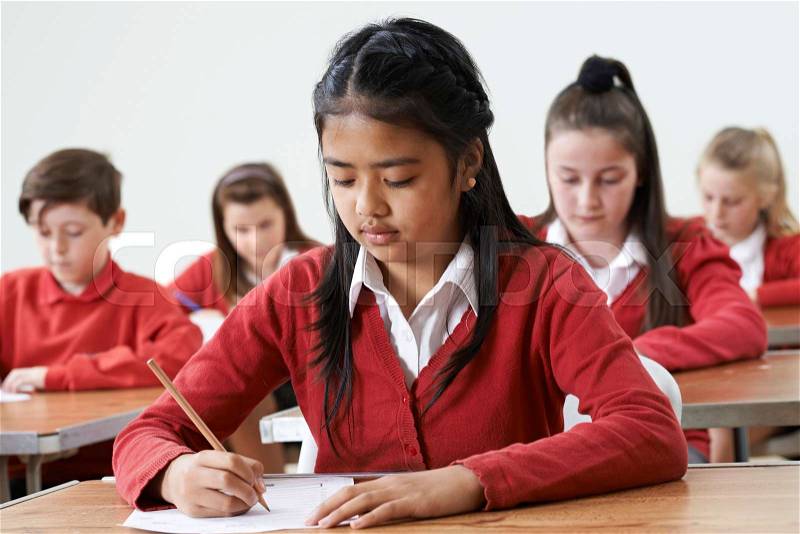 Female Pupil At Desk Taking School Exam , stock photo