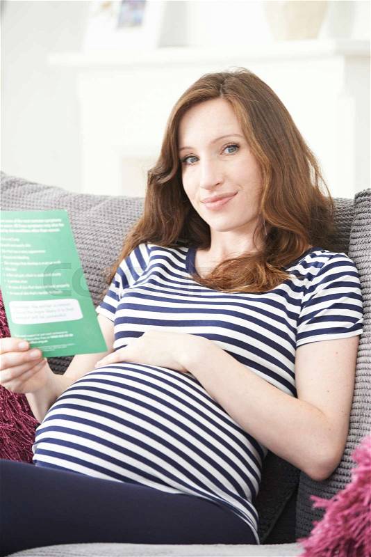Pregnant Woman Reading Leaflet With Medical Advice, stock photo