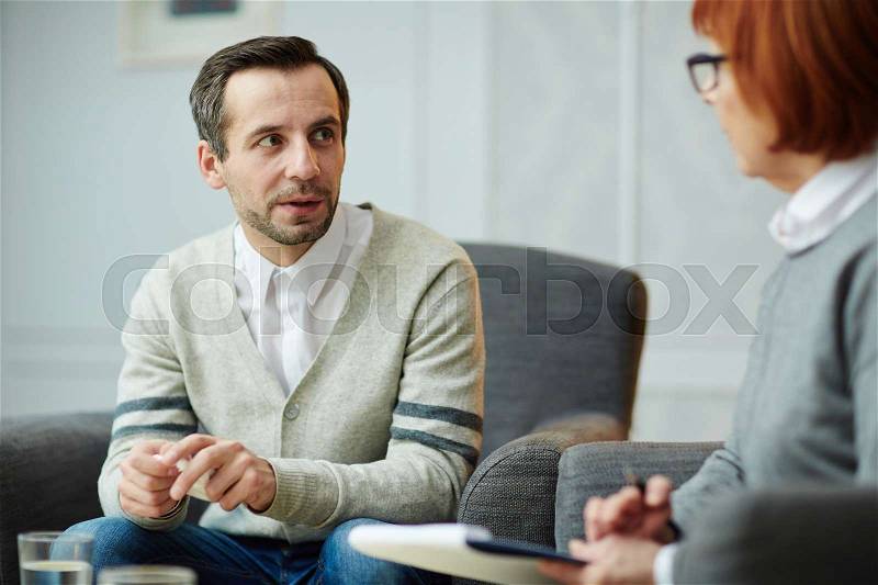 Man sharing his troubles during appointment with counselor, stock photo
