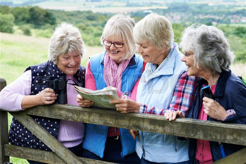 Group Of Senior Female Friends Hiking In Countryside, stock photo