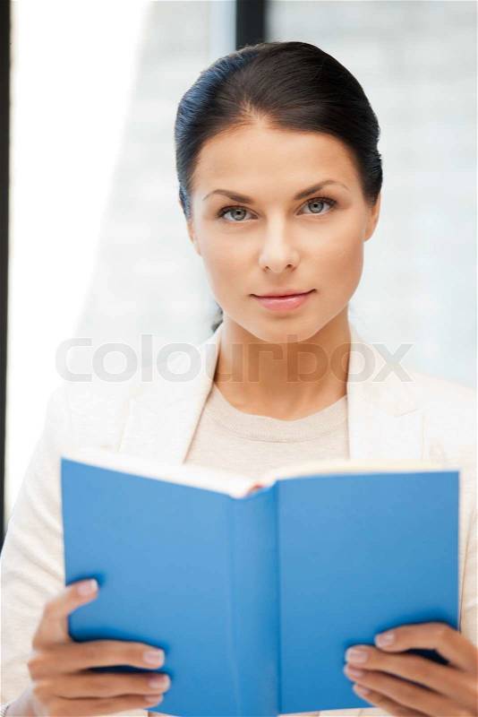 Bright picture of calm and serious woman with book, stock photo