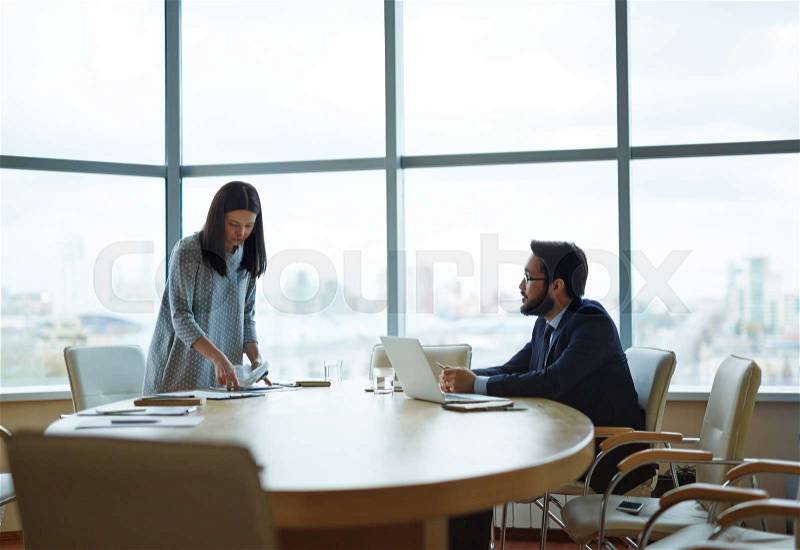 Director talking to his secretary in office before meeting with partners, stock photo