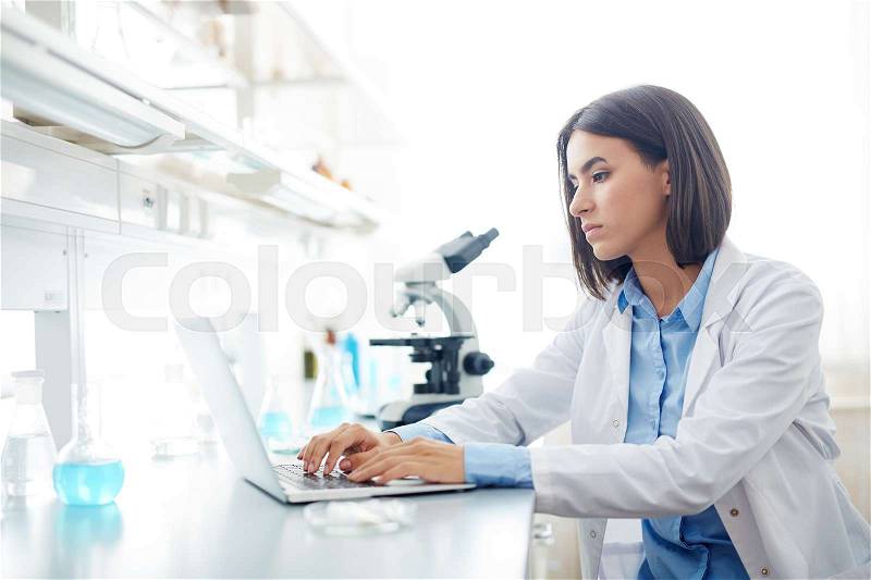 Female scientist browsing in the net during investigation or research, stock photo