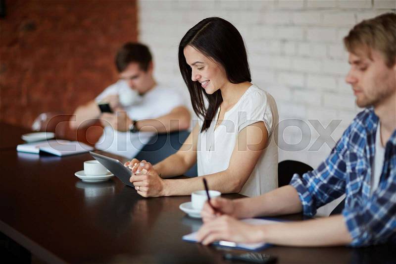 Contemporary specialists planning work or browsing in the net at break, stock photo