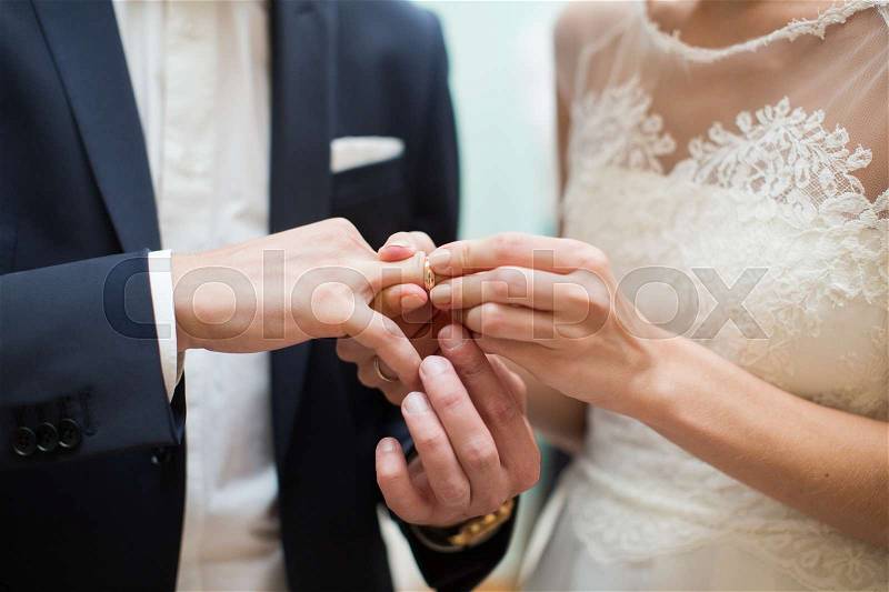 Bride and groom are changing rings on wedding ceremony, stock photo