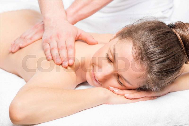 Happy girl relaxed on a massage table during the massage, stock photo