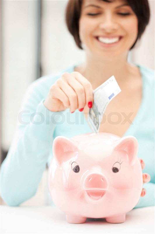Picture of lovely woman with piggy bank and money, stock photo