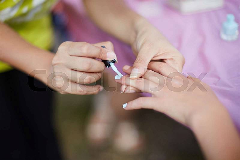 Young girl on a manicure. paint nails with nail polish, stock photo