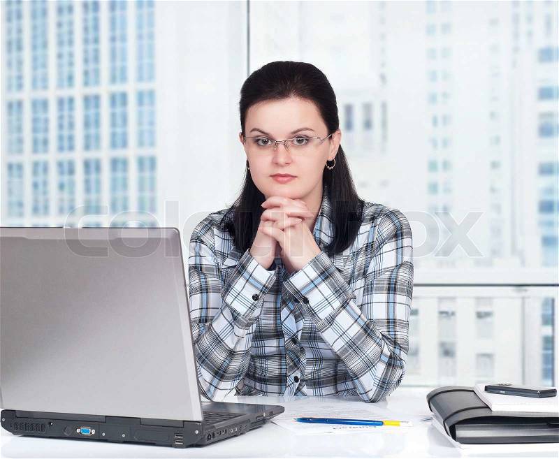 Portrait of a pretty young woman in front of a laptop computer, stock photo