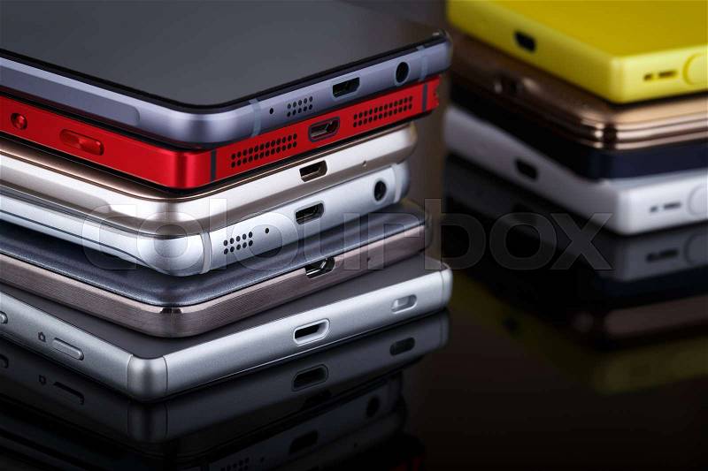 Mobile phone wireless communication technology and mobility business office concept - group of smartphones on black background, stock photo