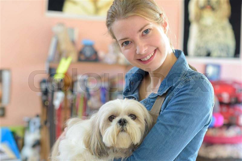 Portrait of young woman and her dog in pet store, stock photo
