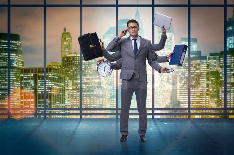 Young businessman in multitasking concept, stock photo