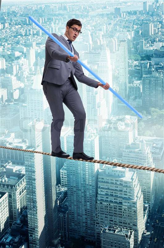 Businessman doing tightrope walking in risk concept, stock photo