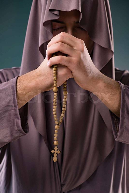 Monk in religious concept on gray background, stock photo
