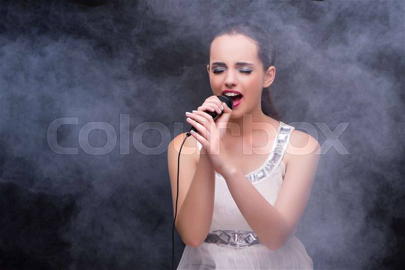 Young girl singing in karaoke club, stock photo
