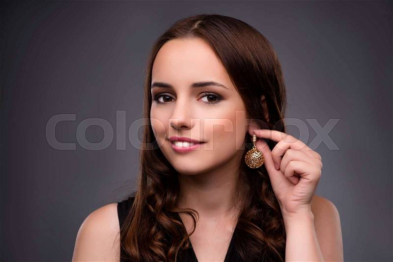Young woman showing her new earrings, stock photo