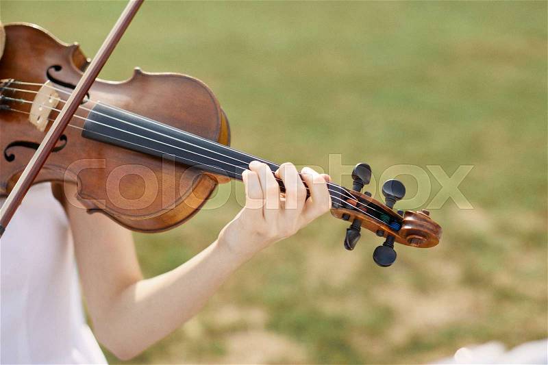 Violinist woman. Young woman playing a violin outside, stock photo