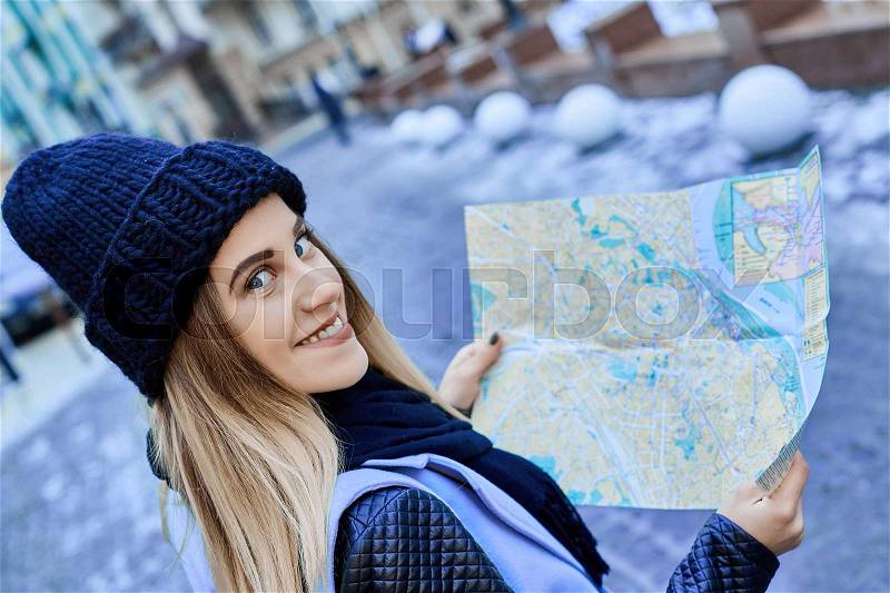 Beautiful girl looking at the map right way in a foreign city. she is a tourist, stock photo