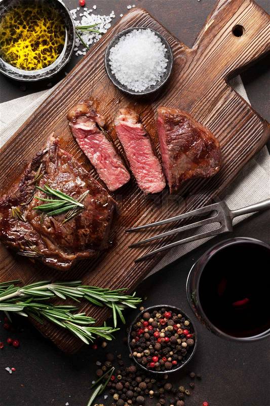 Grilled ribeye beef steak with red wine, herbs and spices. Top view, stock photo