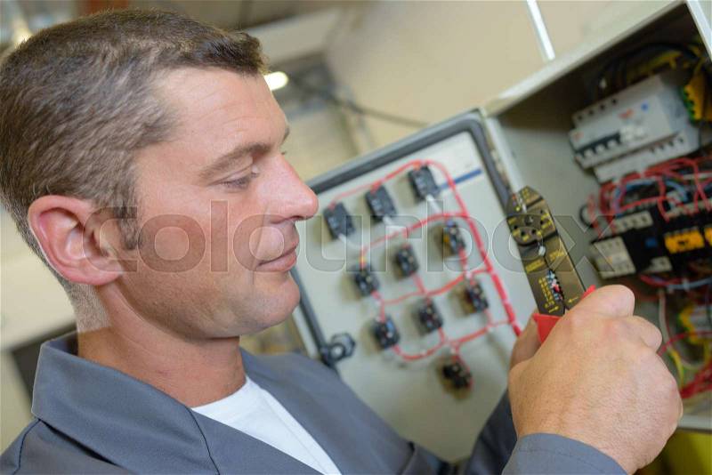 Electrician at fuse box, stock photo