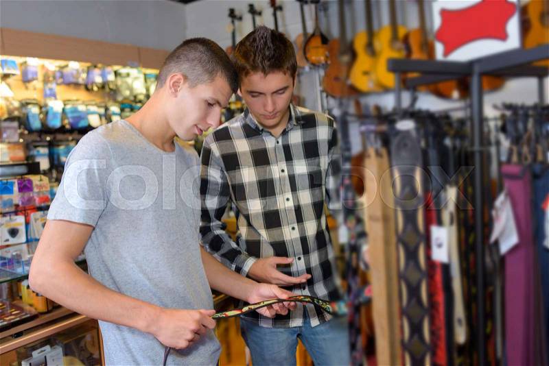 Friends buying guitar straps, stock photo