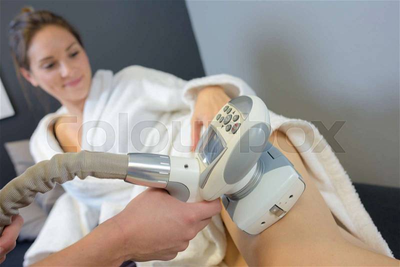 Woman getting laser treatment on her legs, stock photo