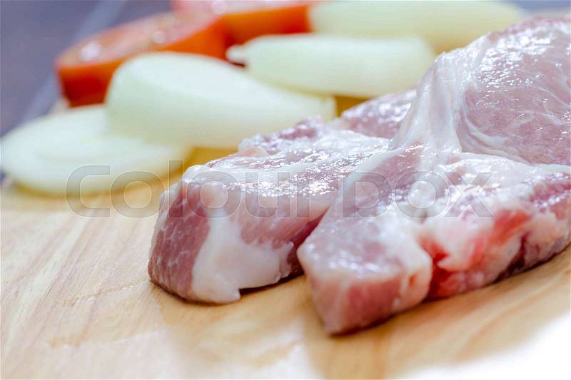 Fresh pork and onion on a wooden board, stock photo