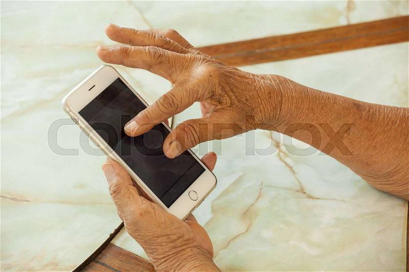 Close up of old woman hand with smart phone, stock photo