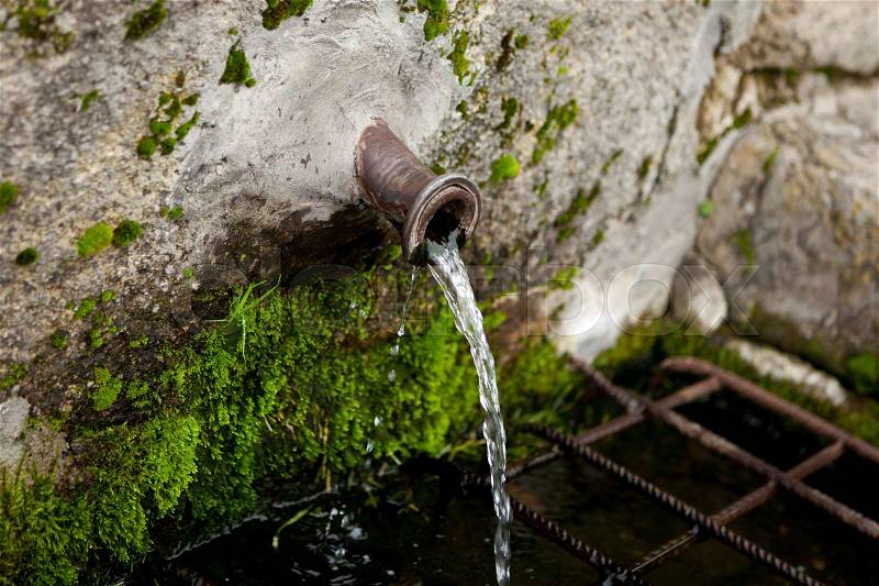 Pipe clean water pouring from a natural source , stock photo