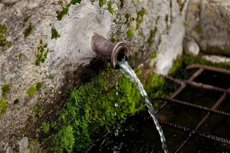 Pipe clean water pouring from a natural source , stock photo